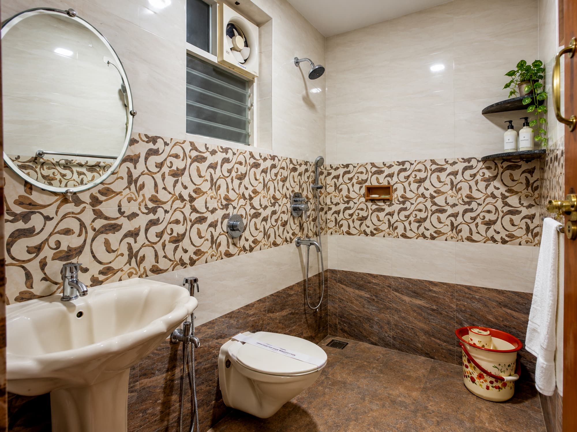 A studio bathroom at Misquita Comforts with a shower and patterned tiling.