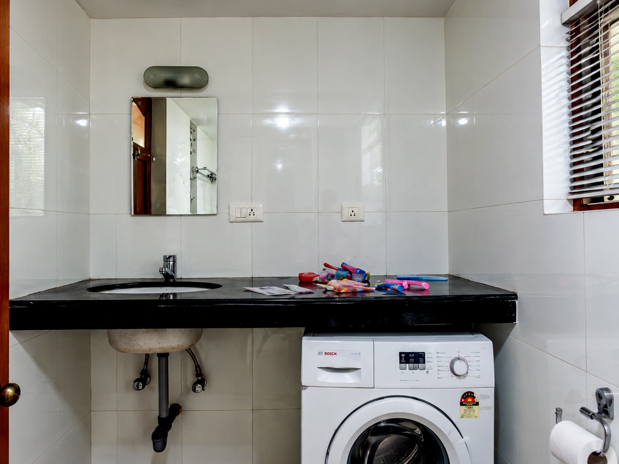 A bathroom at Misquita Exclusive with a granite counter and its own washing machine.